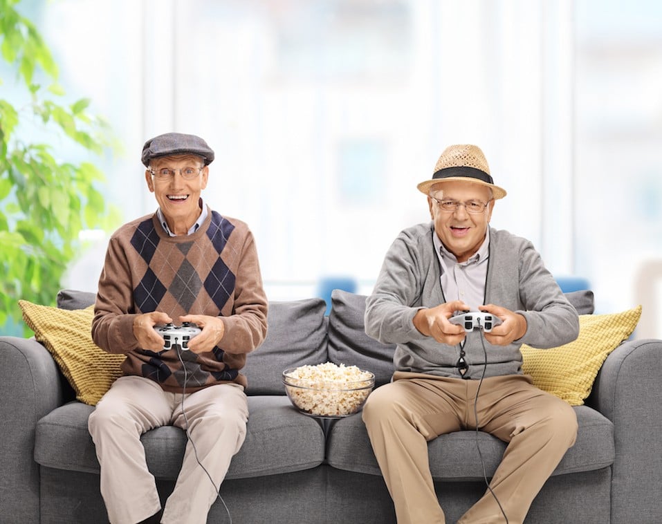 Two joyful seniors playing video games