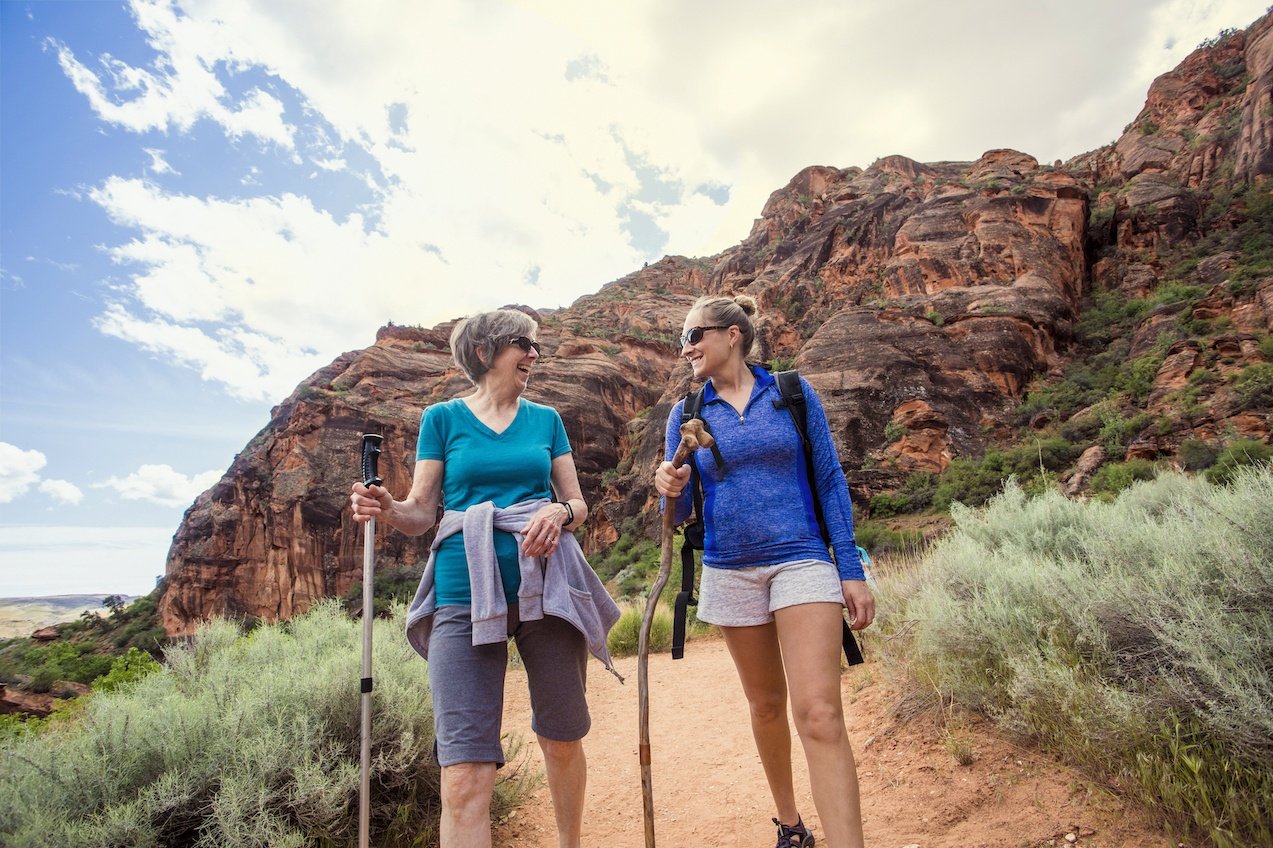 Women hiking together in a beautiful red rock canyon