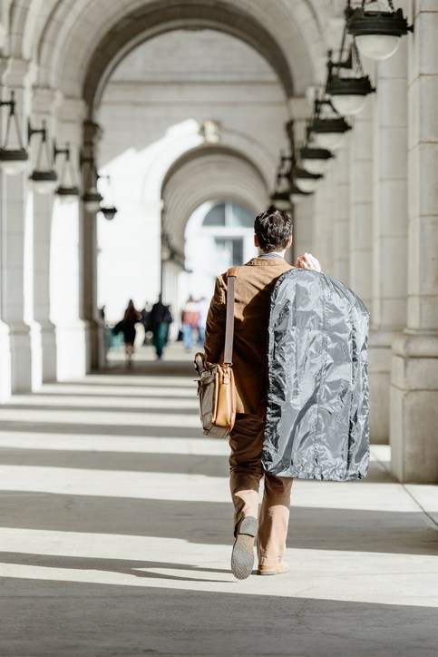 man holding garment bag