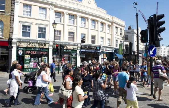 A crowd of pedestrians crosses a street in downtown Greenwich, London, on July 23, 2012, four days ahead of the London 2012 Olympic Games. Greenwich is hosting all of the equestrian events of the summer Olympics.