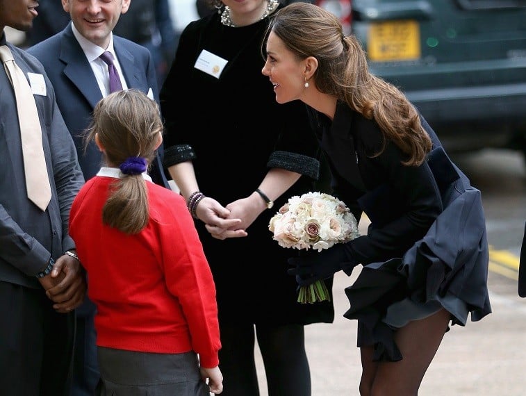 A young girl curtsies as Catherine, Duchess of Cambridge arrives at Clifford Chance to attend the Place2Be Forum at Canary Wharf on November 20, 2013 in London, England.