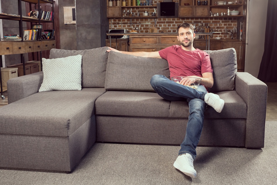 Man sitting on the couch and watching movie