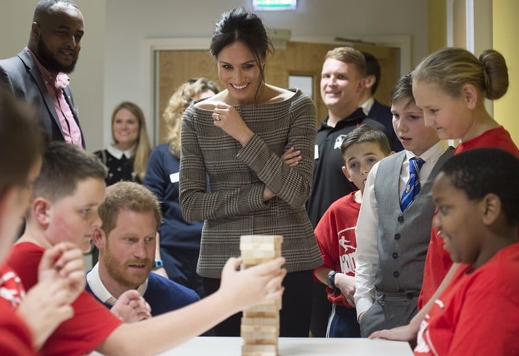 Prince Harry and his fiancee Meghan Markle watch a game of Jenga during their visit to Star Hub on January 18, 2018 in Cardiff, Wales.