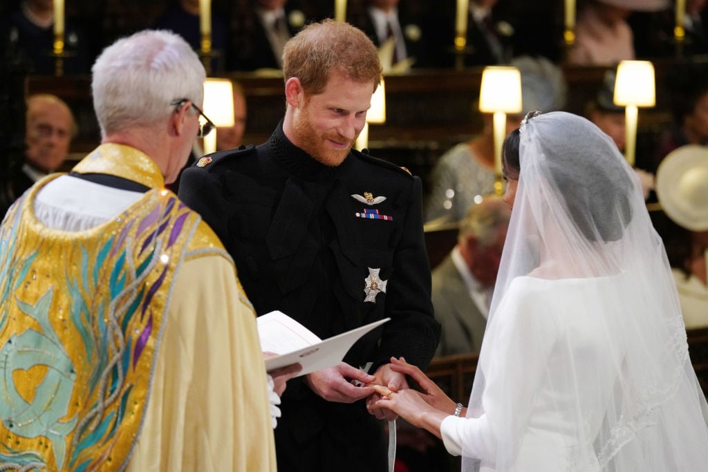 Prince Harry places the ring on Meghan Markle's finger during their wedding ceremony.