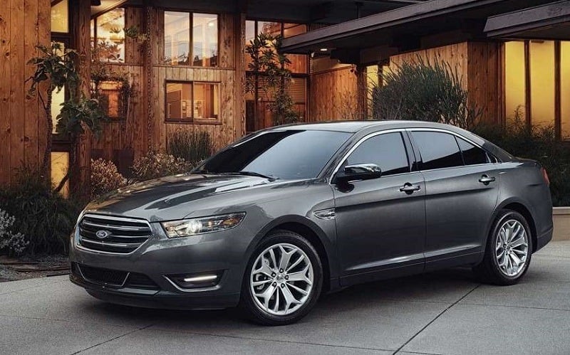 A gray 2018 Ford Taurus parked outside a home