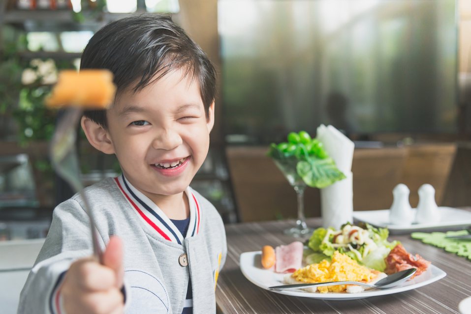 child eating breakfast in a restaurant