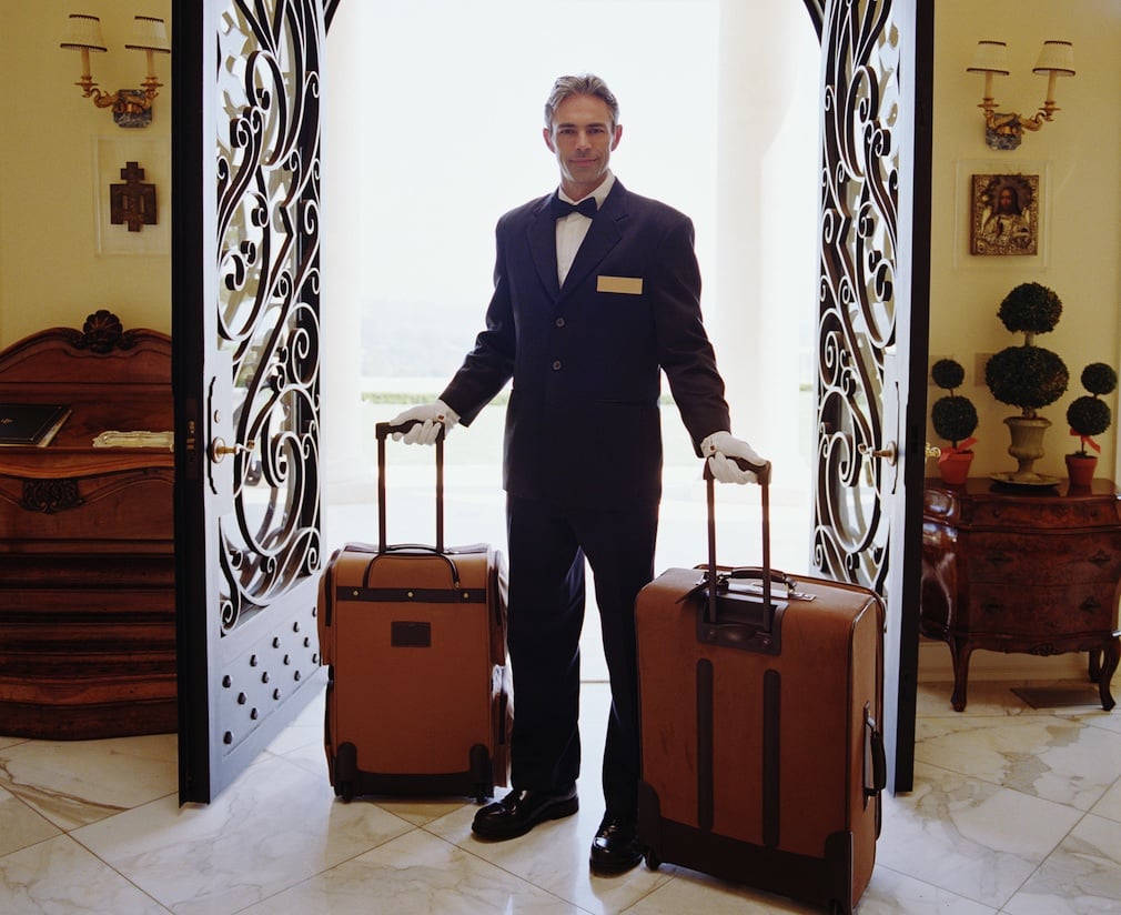 Hotel attendant carrying luggage, portrait