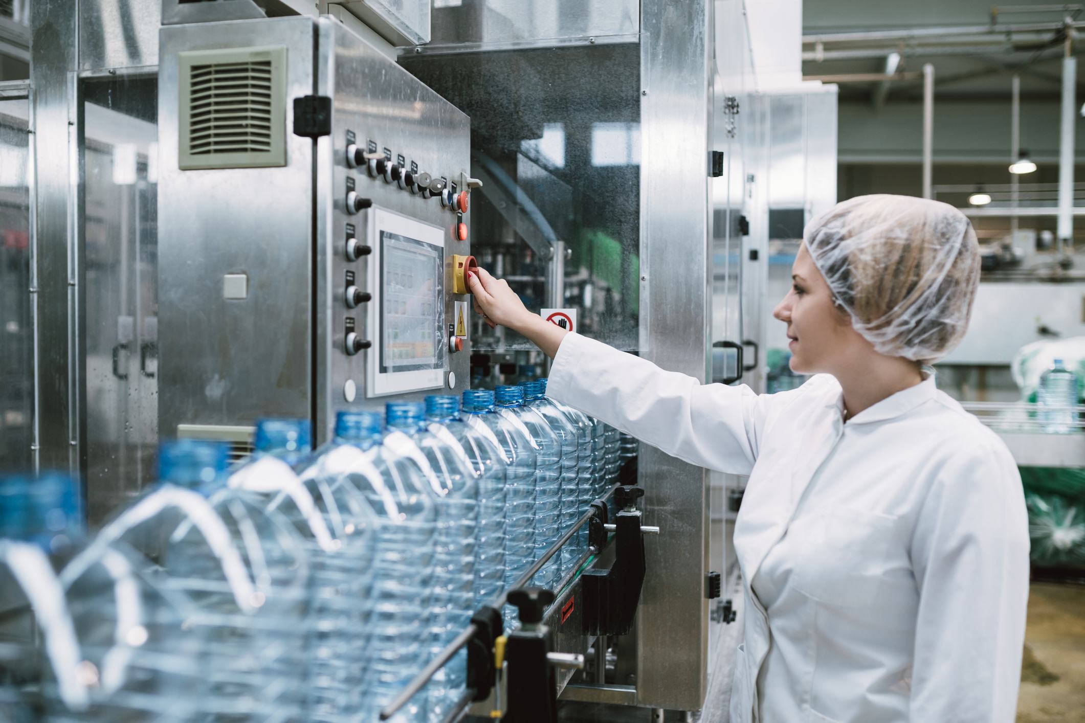 Female bottler packaging water bottles in factory