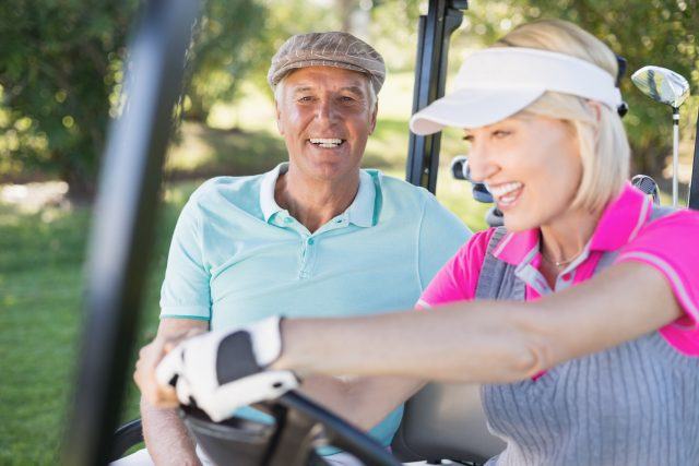Mature couple enjoying in golf cart Mature couple enjoying in golf cart
