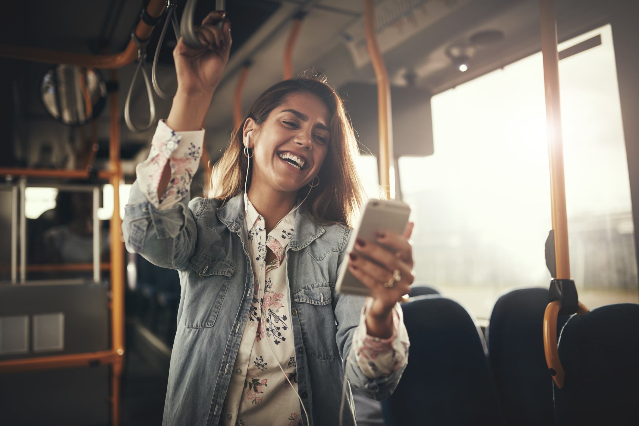Young woman laughing at her phone