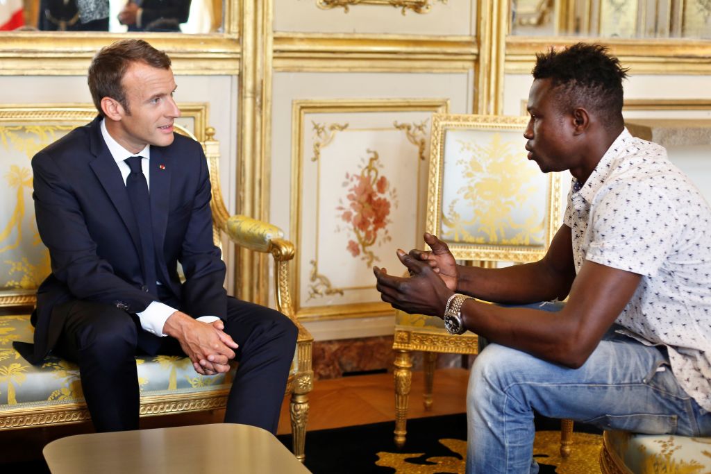 French President Emmanuel Macron (L) speaks with Mamoudou Gassama