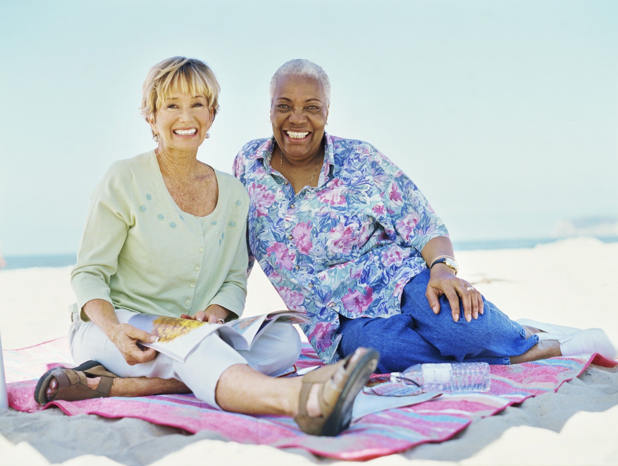 portrait of two mature women sitting on the beach
