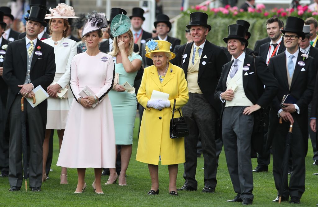 Britain's Queen Elizabeth II (C) stands with her Bloodstock and Racing Advisor, John Warren (3R) as they watch the Wolferton Rated Stakes race on day one of the Royal Ascot horse racin