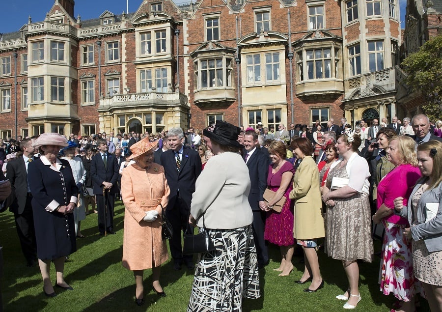 Queen Elizabeth II (C) talks with guests during a garden party in honour of her diamond jubilee at the Queen's Sandringham Estate