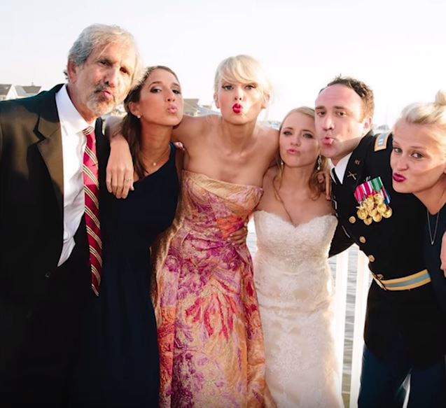 Taylor Swift poses with the bride and groom