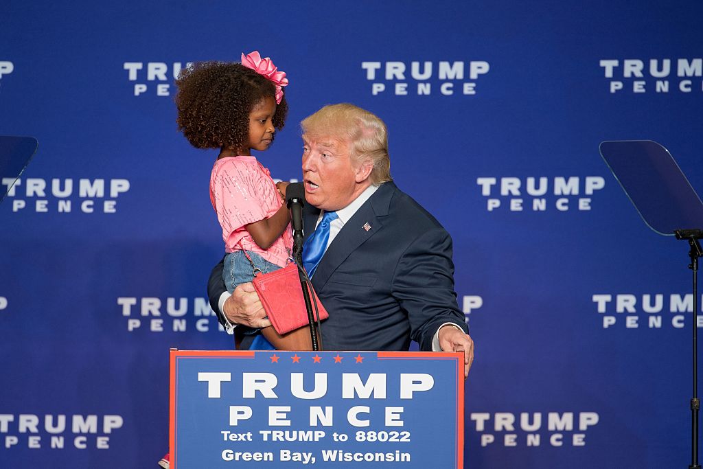 Republican presidential nominee Donald Trump holds a child