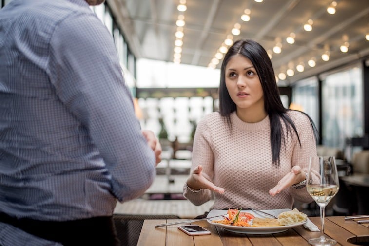 Unhappy customer with her meal Portrait of woman complaining about food quality in restaurant.
