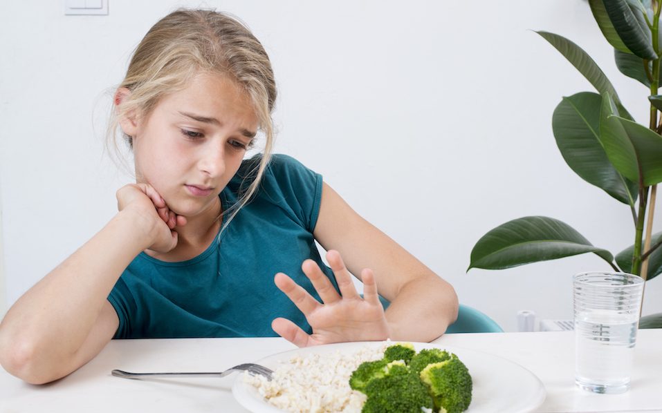 Girl pushing her dinner plate away Girl pushing her dinner plate away