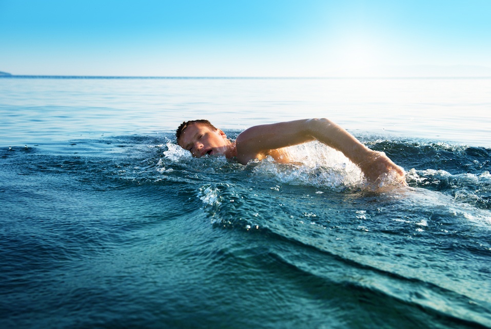 young man swiming in oceans water
