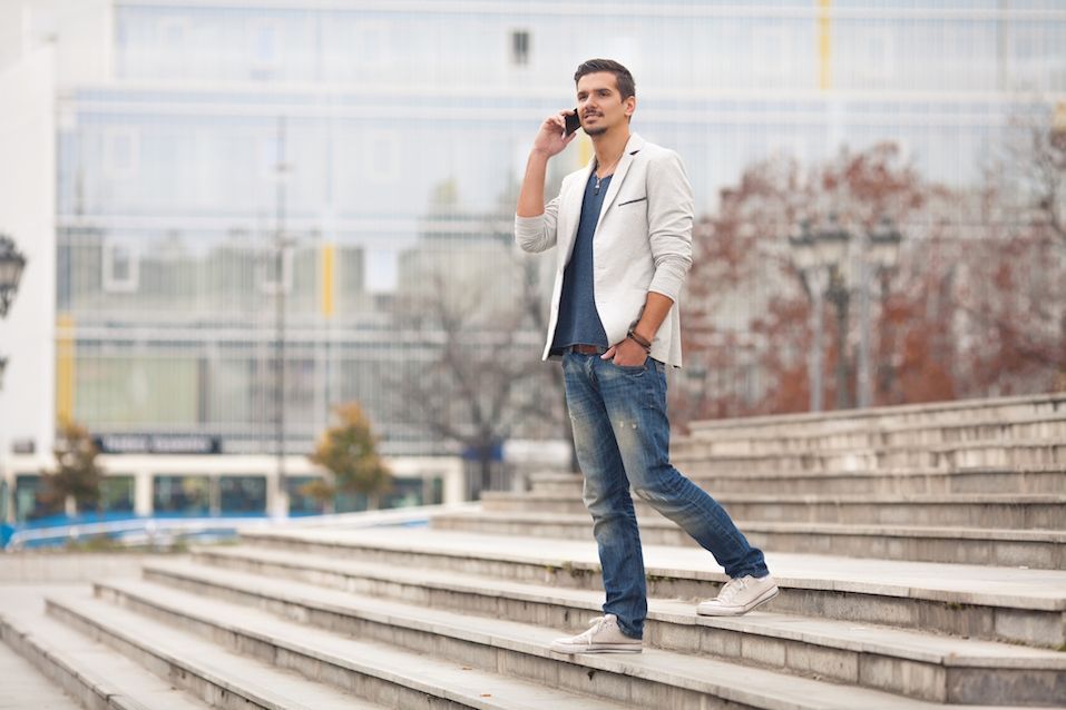 Young man walking down the stairs and talking on the phone