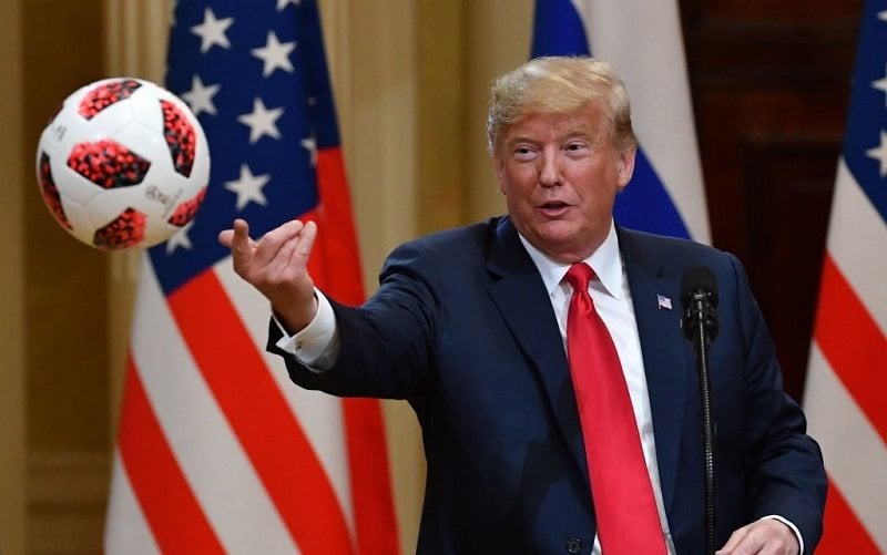 President Donald Trump throws to his wife (unseen) a ball of the 2018 football World Cup that he received from Russia's President as a present during a joint press conference after a meeting at the Presidential Palace in Helsinki, on July 16, 2018. 