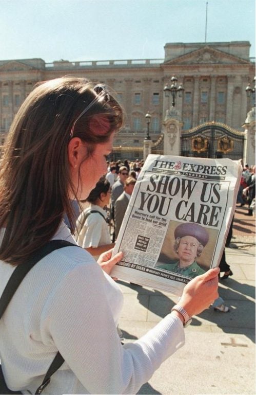 Outside Buckingham Palace, a Londoner reads headlines criticizing the Queen's silence since Princess Diana's death