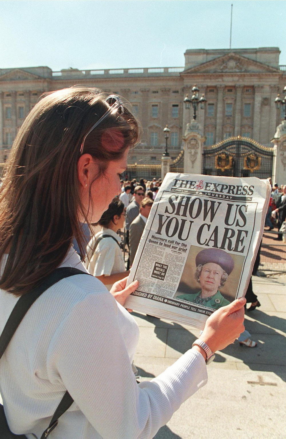 Outside Buckingham Palace, a Londoner reads headlines criticizing the Queen's silence since Princess Diana's death