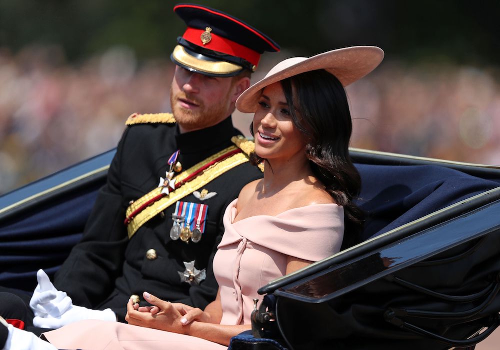 Prince Harry and Meghan Markle ride in a horse-drawn carriage