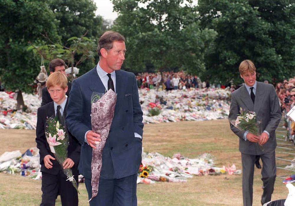 Prince Harry and Prince William collect floral tributes to their mother, Diana, Princess of Wales, from the crowd at Kensington Palace