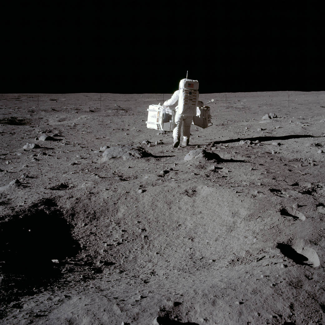 Buzz Aldrin carries the Passive Seismic Experiments Package and the Laser Ranging Retroreflector