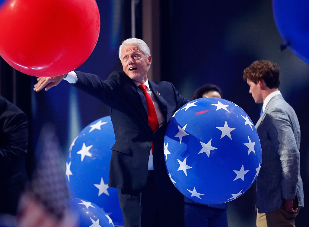 Former US President Bill Clinton plays with balloons