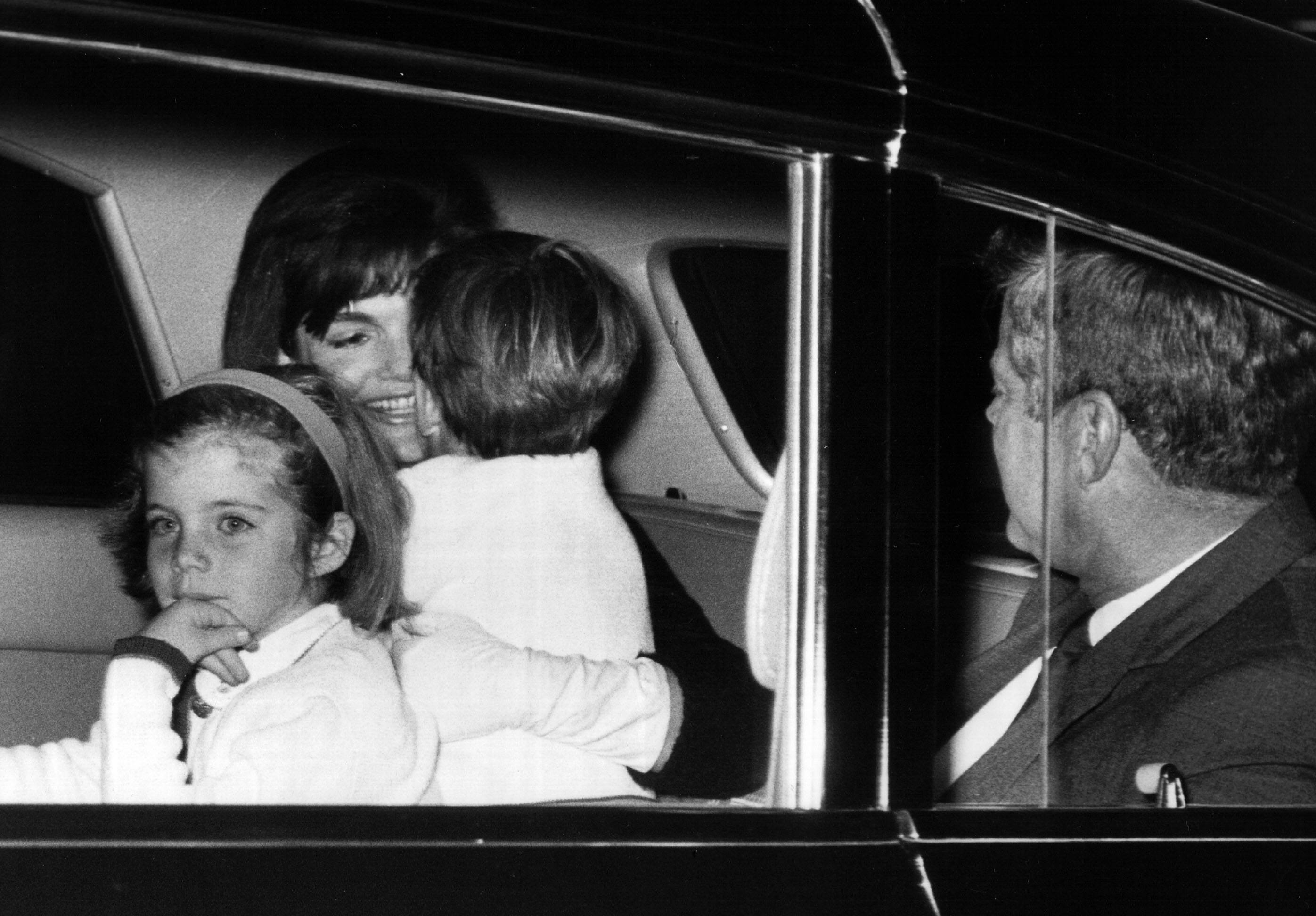 First Lady Jackie Kennedy is greeted by her children after arriving from a trip