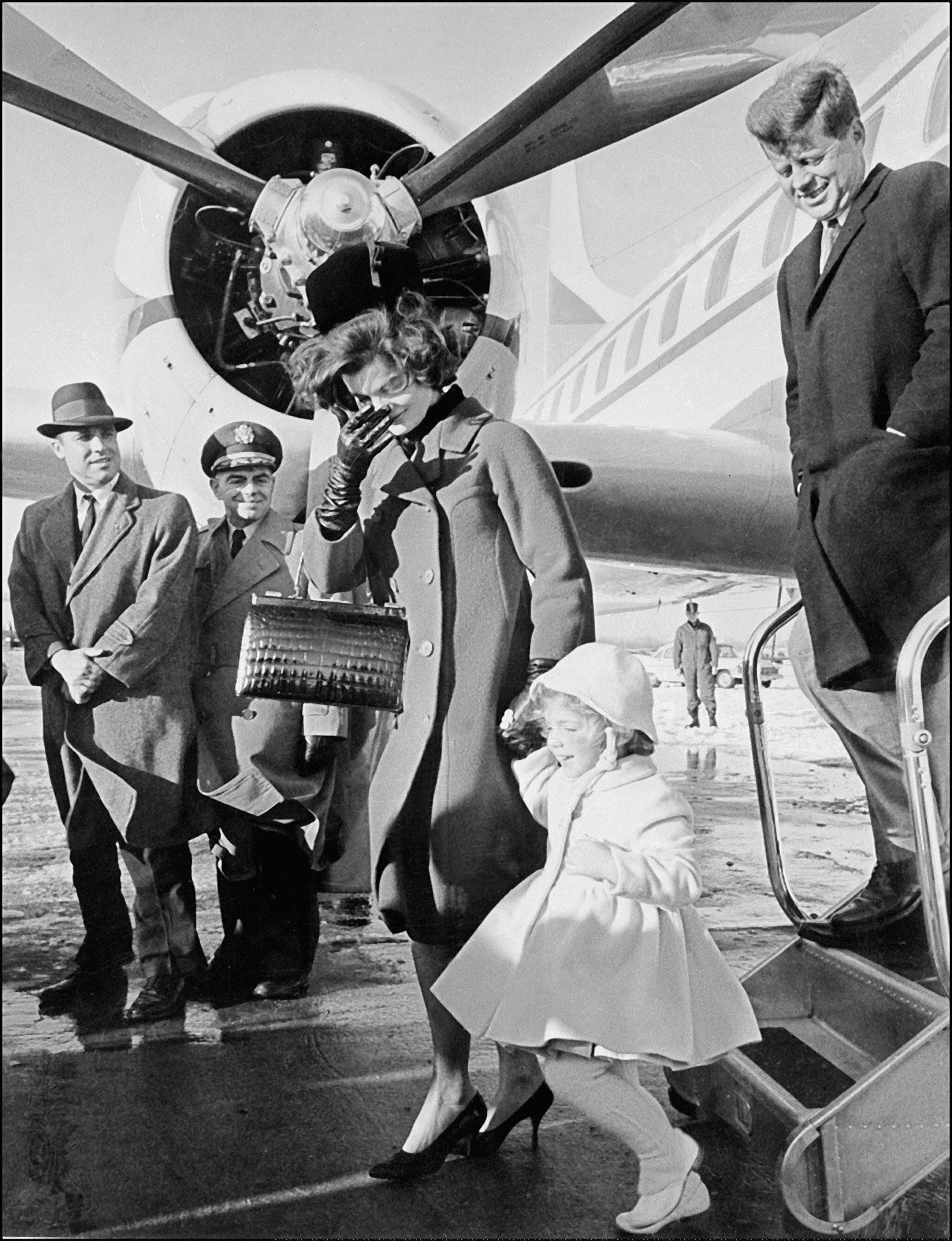 John Fitzgerald Kennedy, his wife Jacqueline, and their daughter Caroline arriving at an airport
