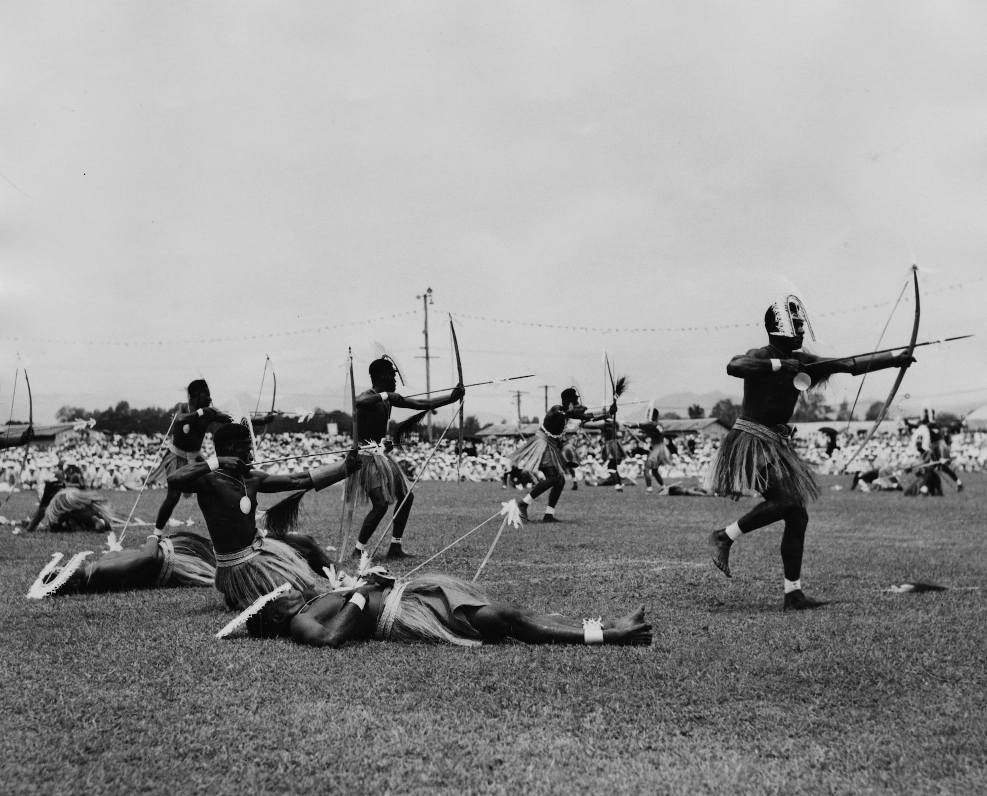 Local people in the Torres Strait Islands perform a war dance in front of Queen Elizabeth II and Prince Philip