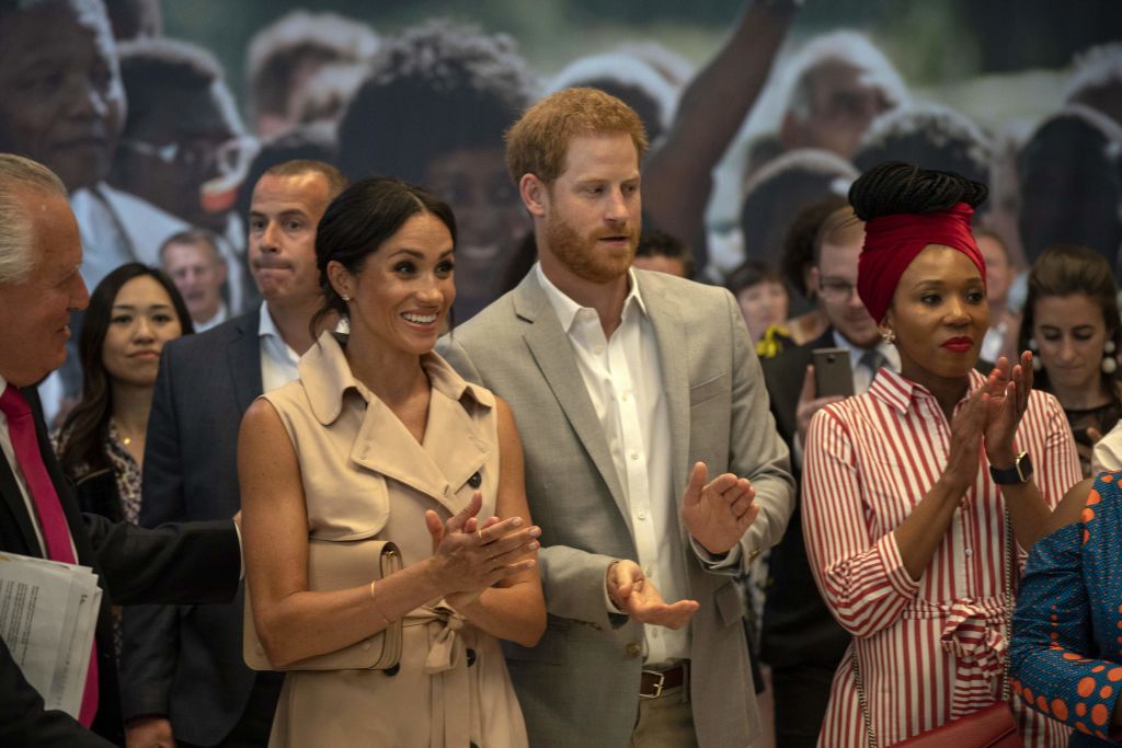 Prince Harry, Duke of Sussex and Meghan, Duchess of Sussex gesture during a visit to the Nelson Mandela Centenary Exhibition, which explores the life and times of Nelson Mandela