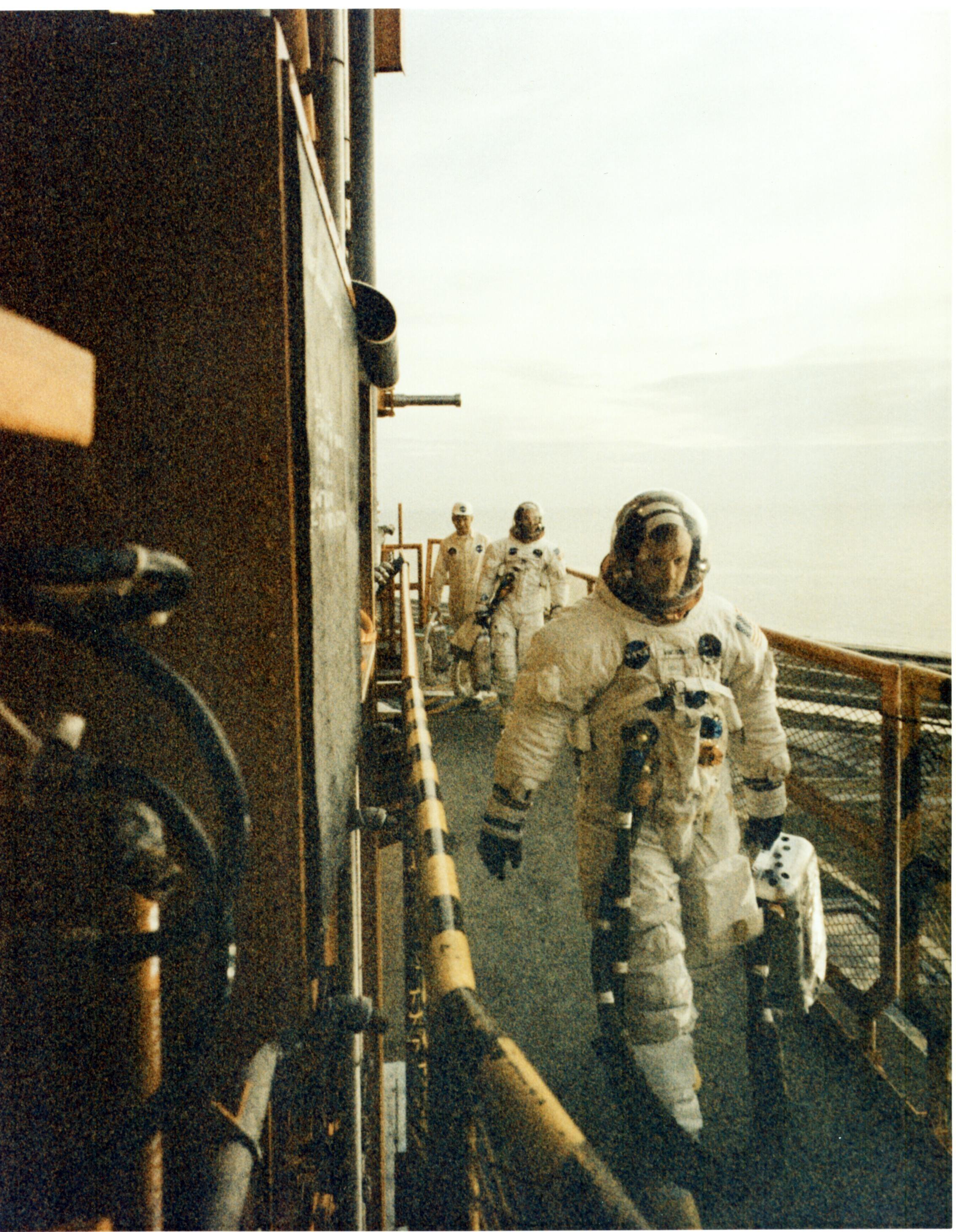 Neil Armstrong and Buzz Aldrin walk across the mobile launcher to enter the Apollo 11 spacecraft