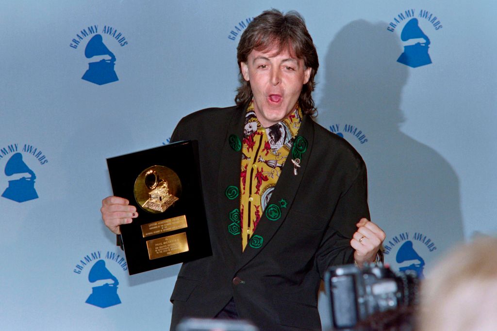 Paul MCCARTNEY smiles and pumps his fist while holding his Lifetime Achievement Grammy