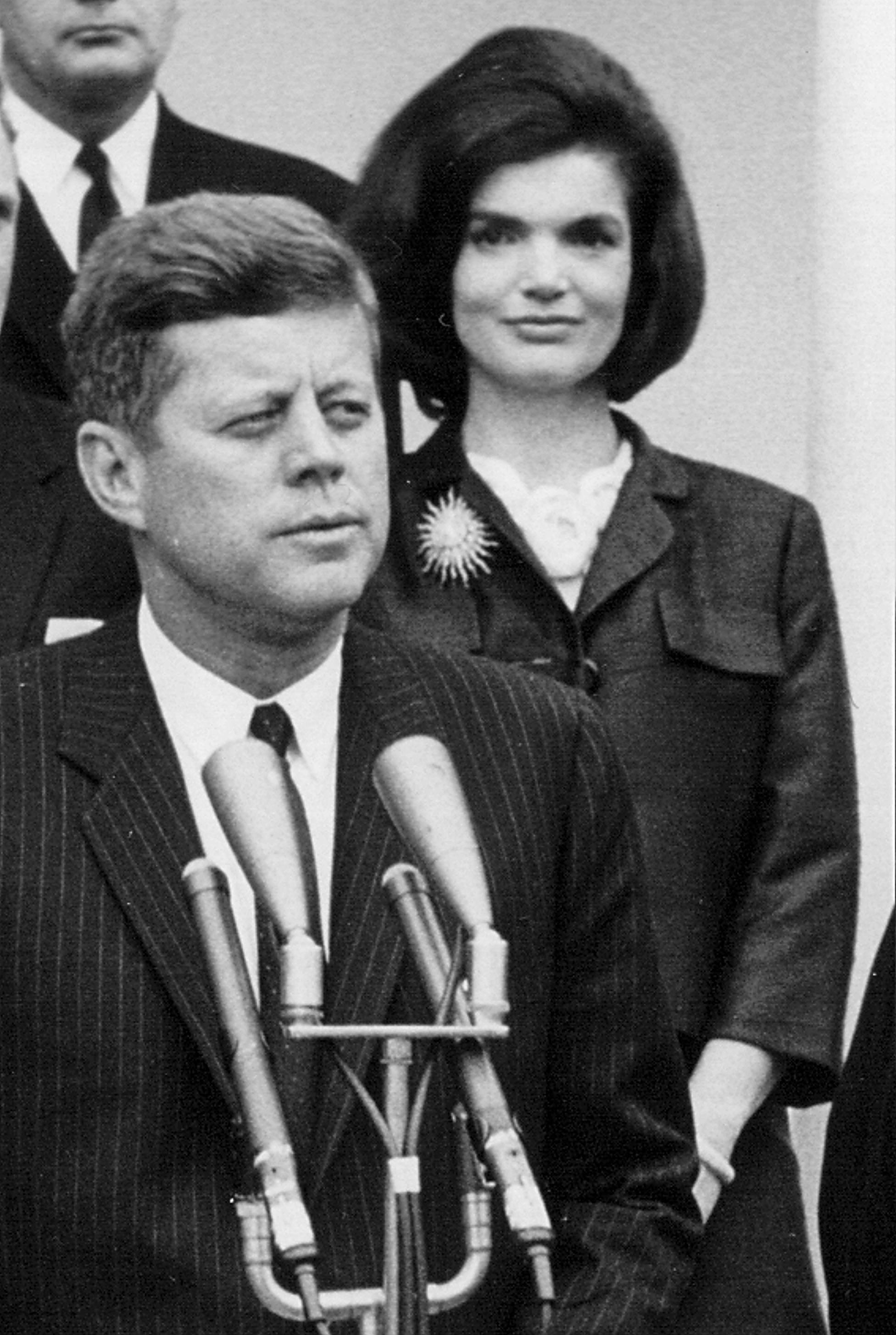 President John F. Kennedy speaks during a press conference as First Lady Jackie Kennedy looks on