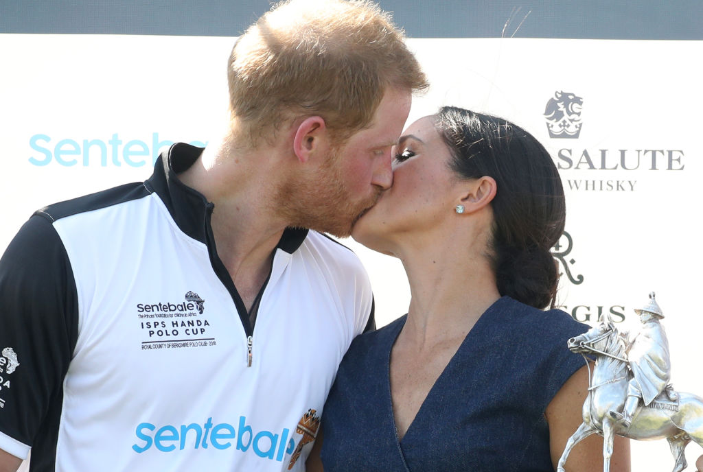 Meghan Duchess of Sussex and Prince Harry Duke of Sussex kiss after posing with the trophy after the Sentebale Polo 2018 held at the Royal County of Berkshire Polo Club on July 26, 2018 in Windsor, England
