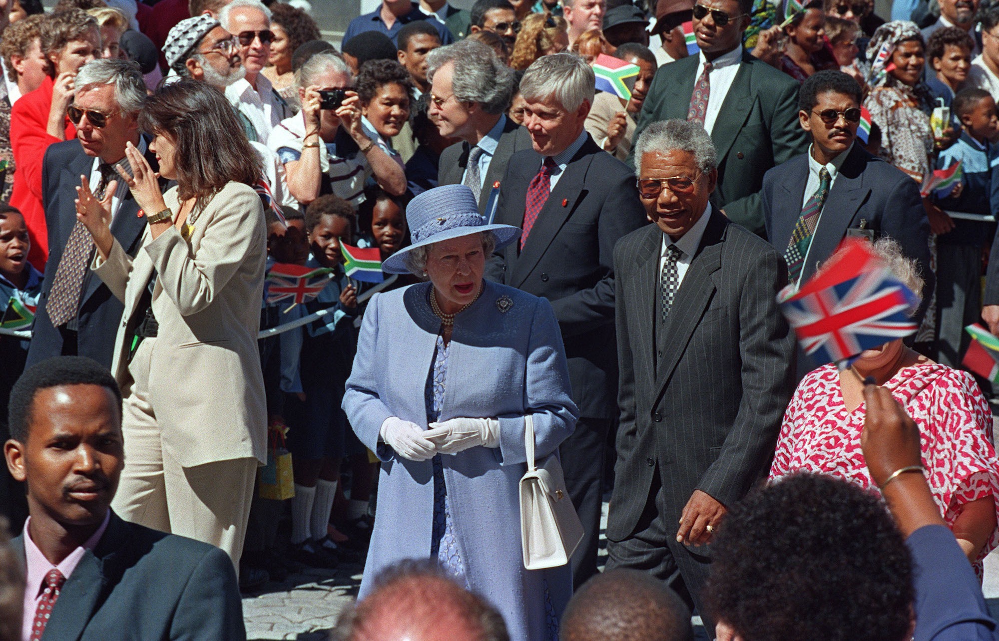 Queen Elizabeth II and President Nelson Mandela walk from office of the president to parliament in Cape Town