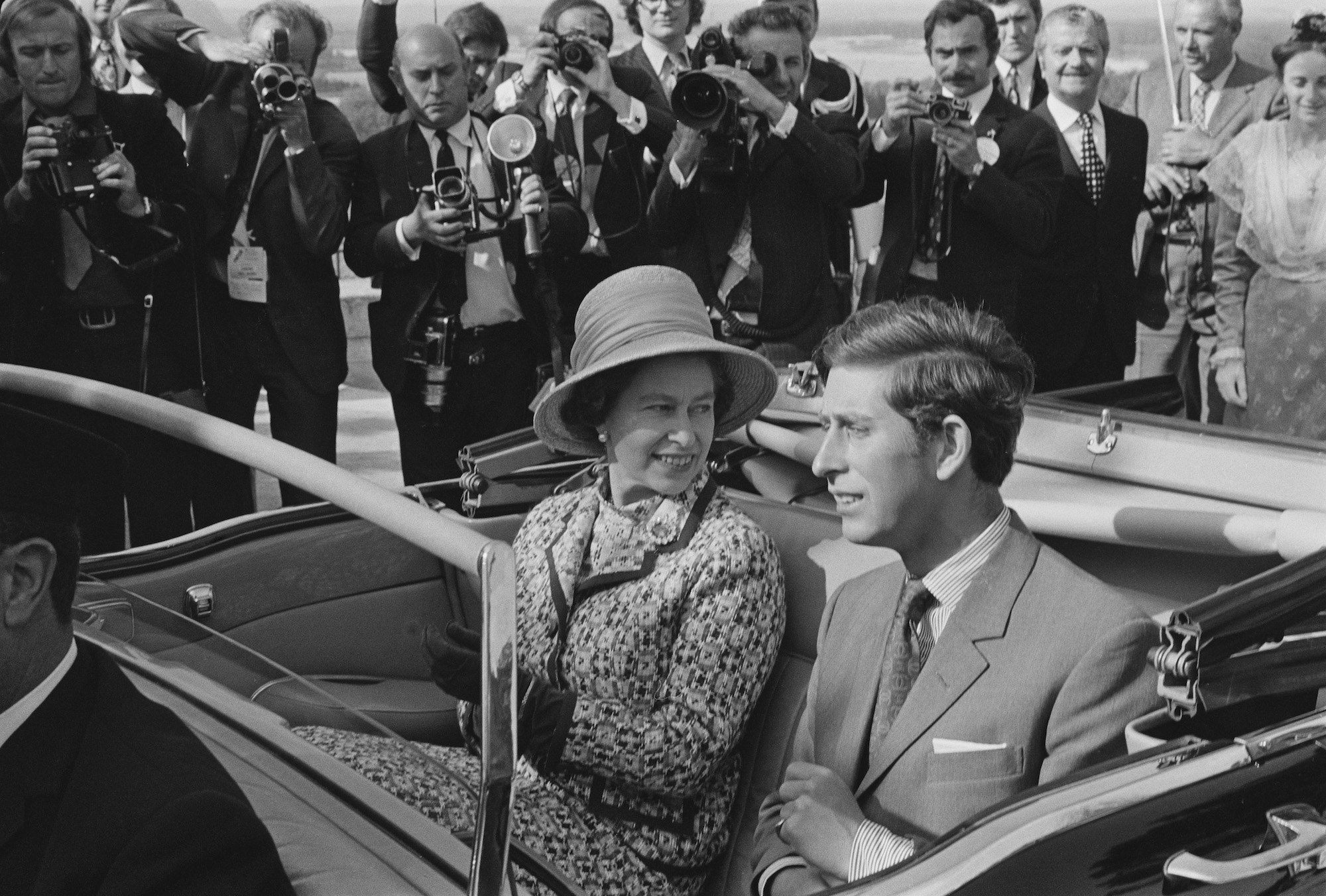 Queen Elizabeth II and Prince Charles travel in an open top car in Avignon
