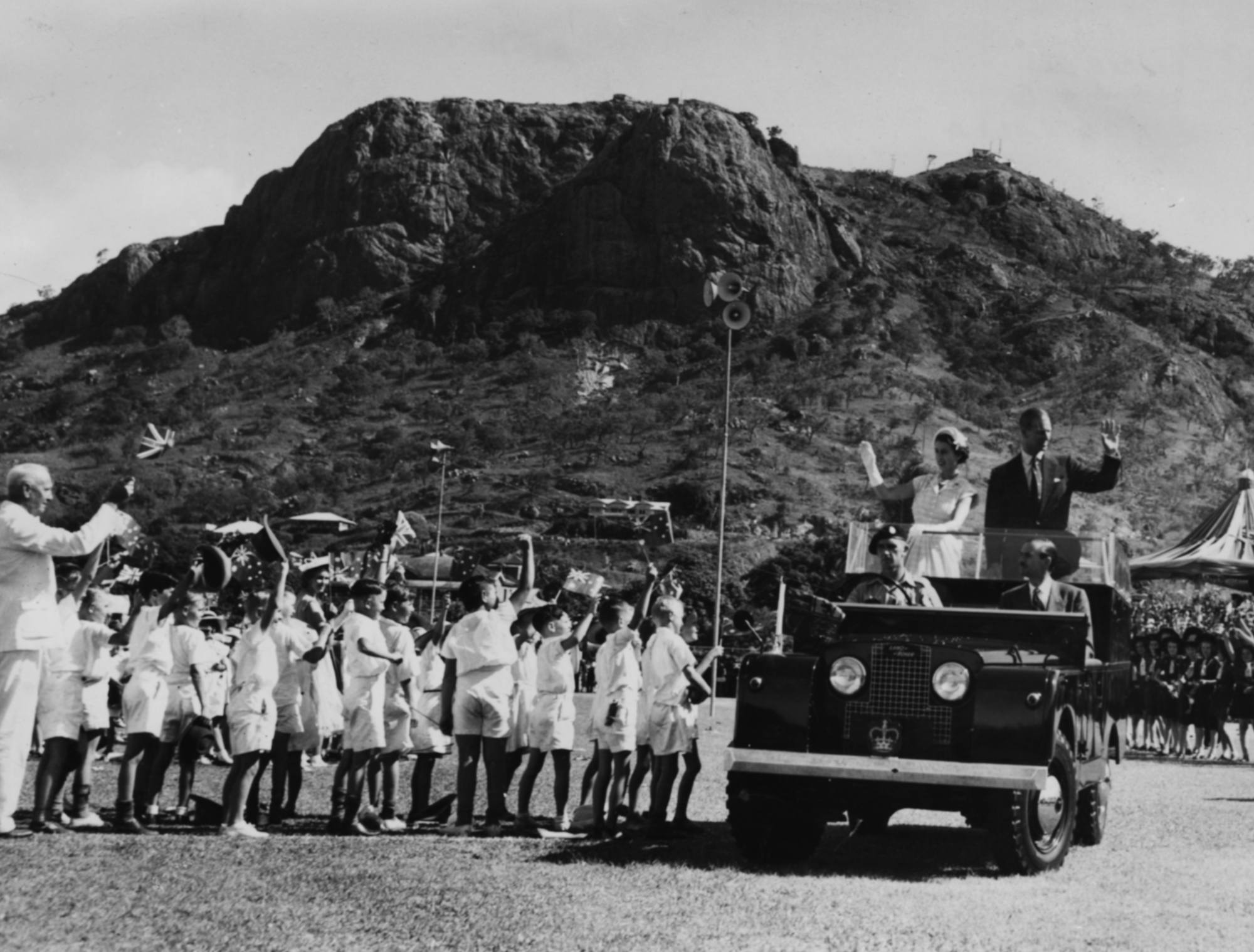 Queen Elizabeth II and Prince Philip wave from the back of their Land Rover in Bundaberg, Australia