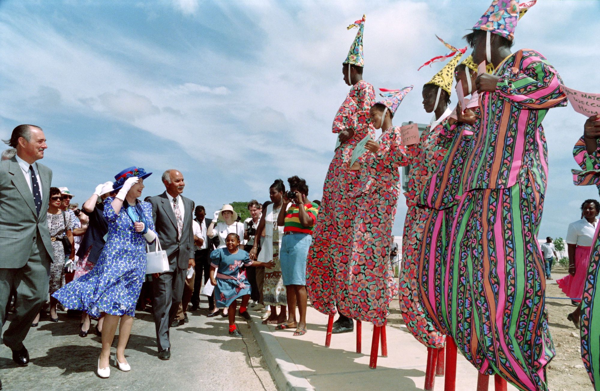 Queen Elizabeth II watches Anguillan boys on stilts