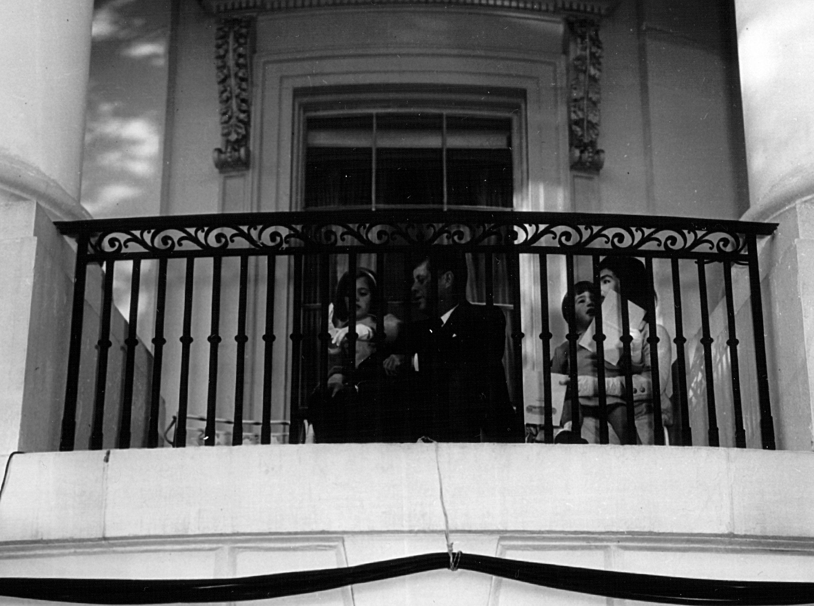 The President and Mrs. Kennedy sit with their children in the South Portico