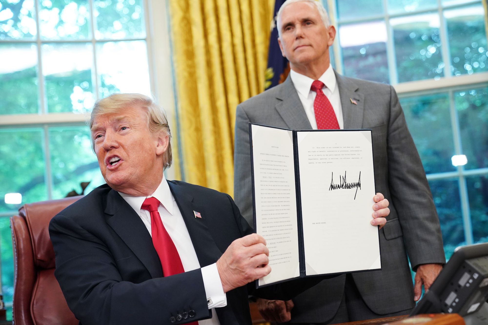 Donald Trump shows an executive order on immigration