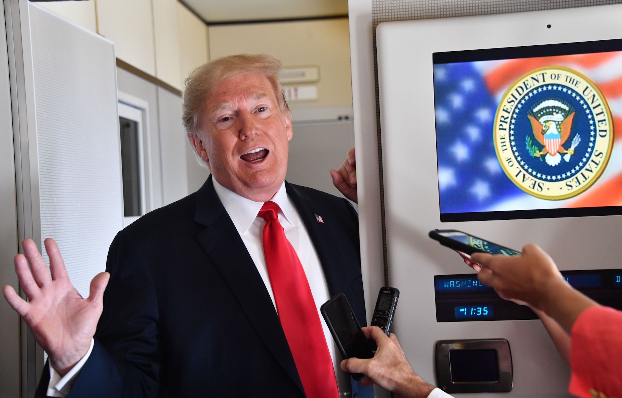 Donald Trump speaks to the press aboard Air Force One