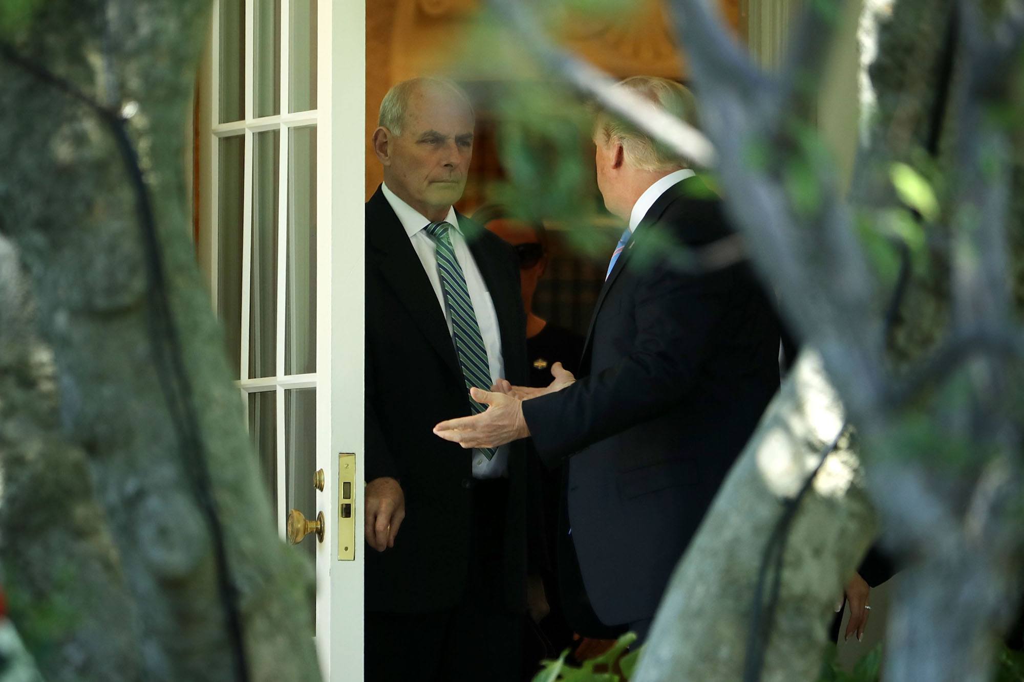 Donald Trump talks with his Chief of Staff John Kelly before departing the White House