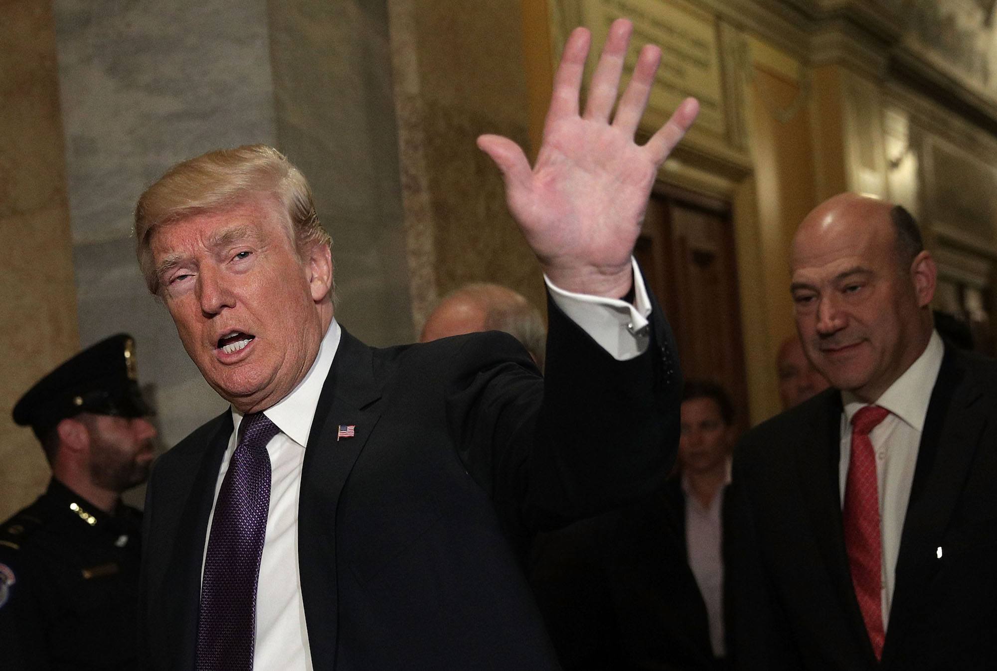 Donald Trump waves as he arrives at the Capitol