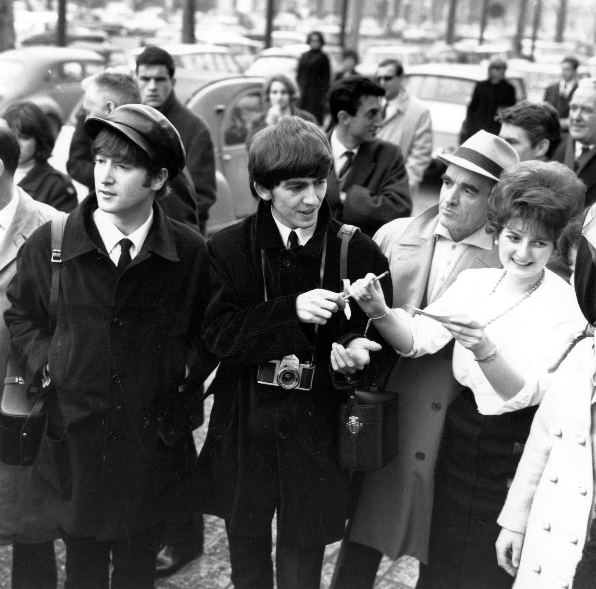 John Lennon and George Harrison sign autographs in Paris