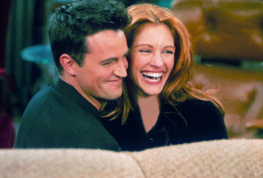 Actor Matthew Perry and actress Julia Roberts hug each other on the set of "Friends"